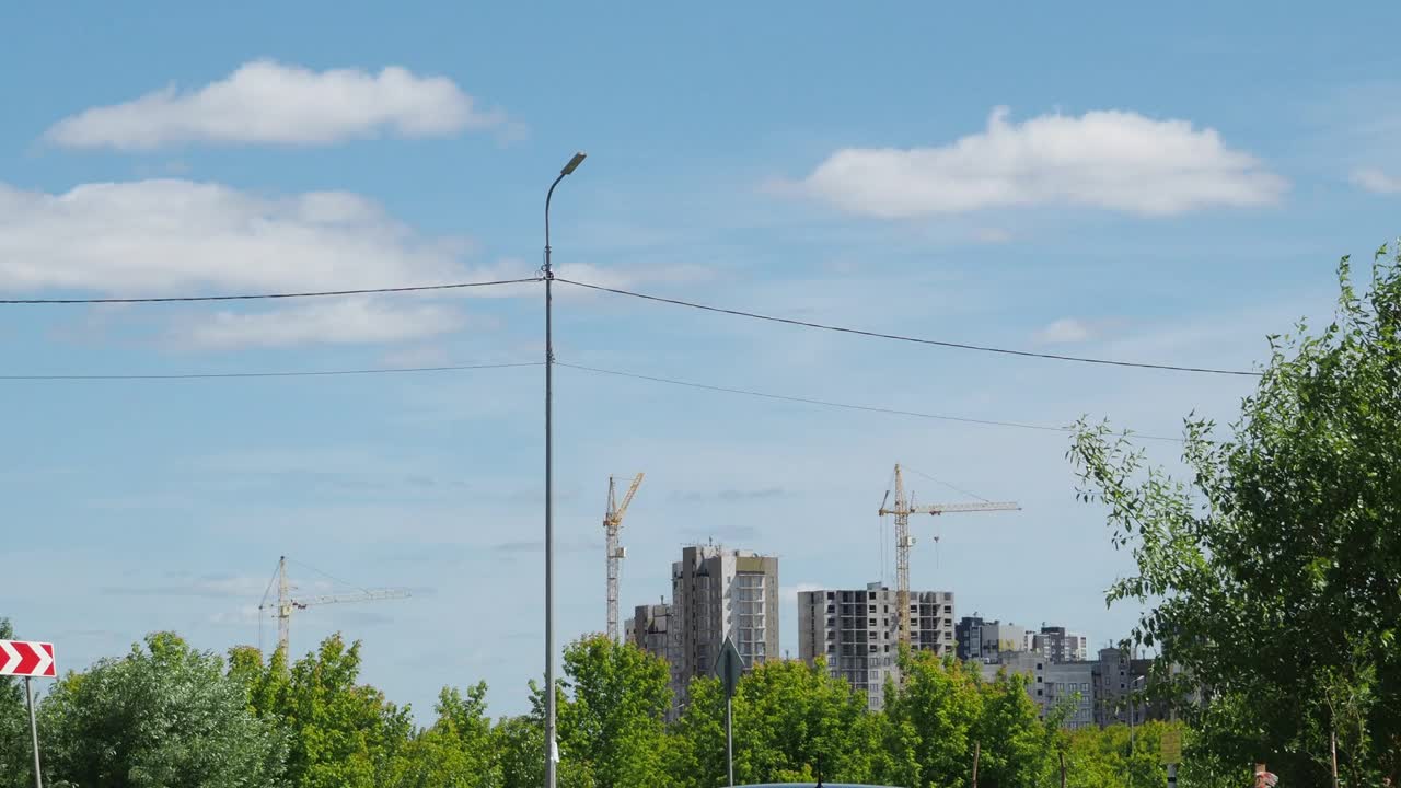 蓝天背景下的新建筑工地。钢框架结构、结构钢梁在施工现场建造大型建筑物。工程机械。现代城市视频素材