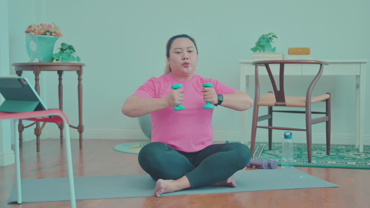 亚洲大块头女性在家用平板电脑锻炼身体视频素材