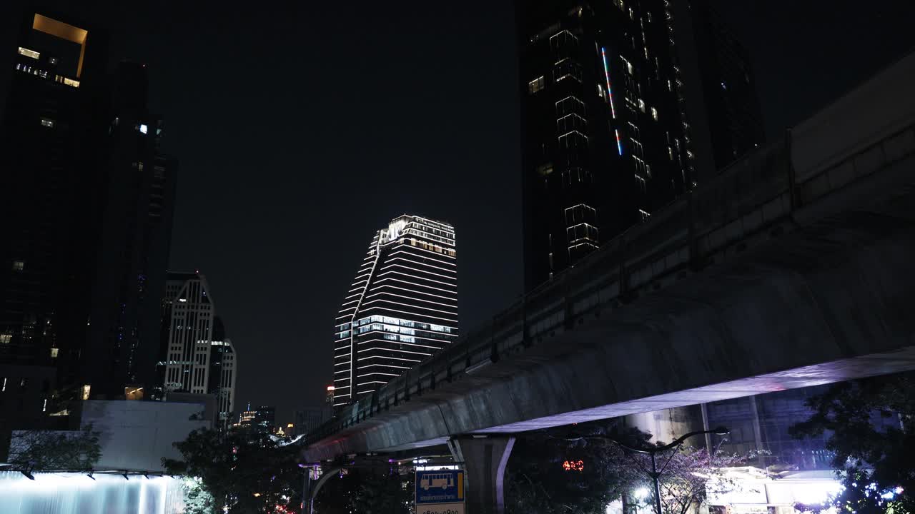 列车在建筑物之间的地面上移动，BTS轻轨城市地铁，泰国曼谷的现代都市景观视频素材