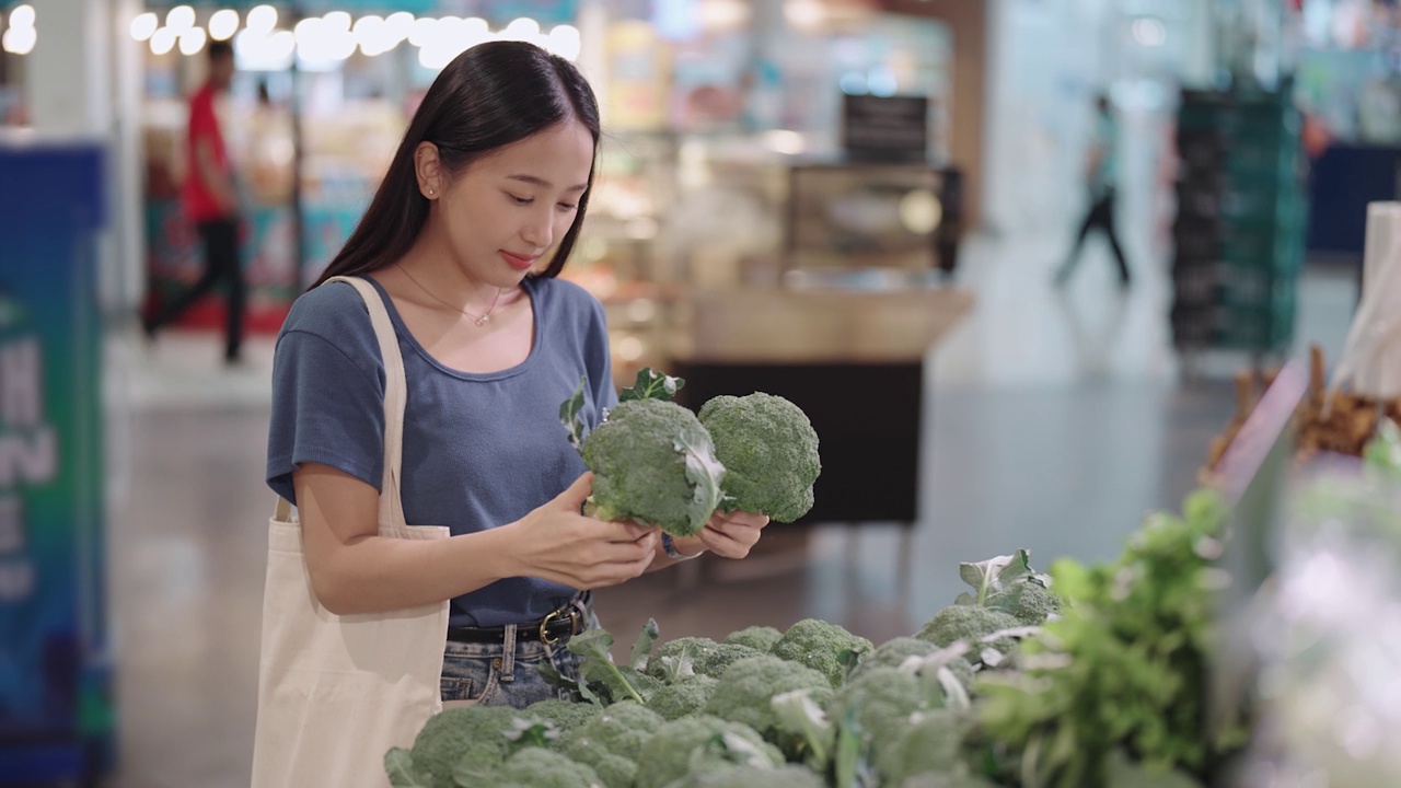 一位亚洲妇女在杂货店挑选蔬菜视频素材