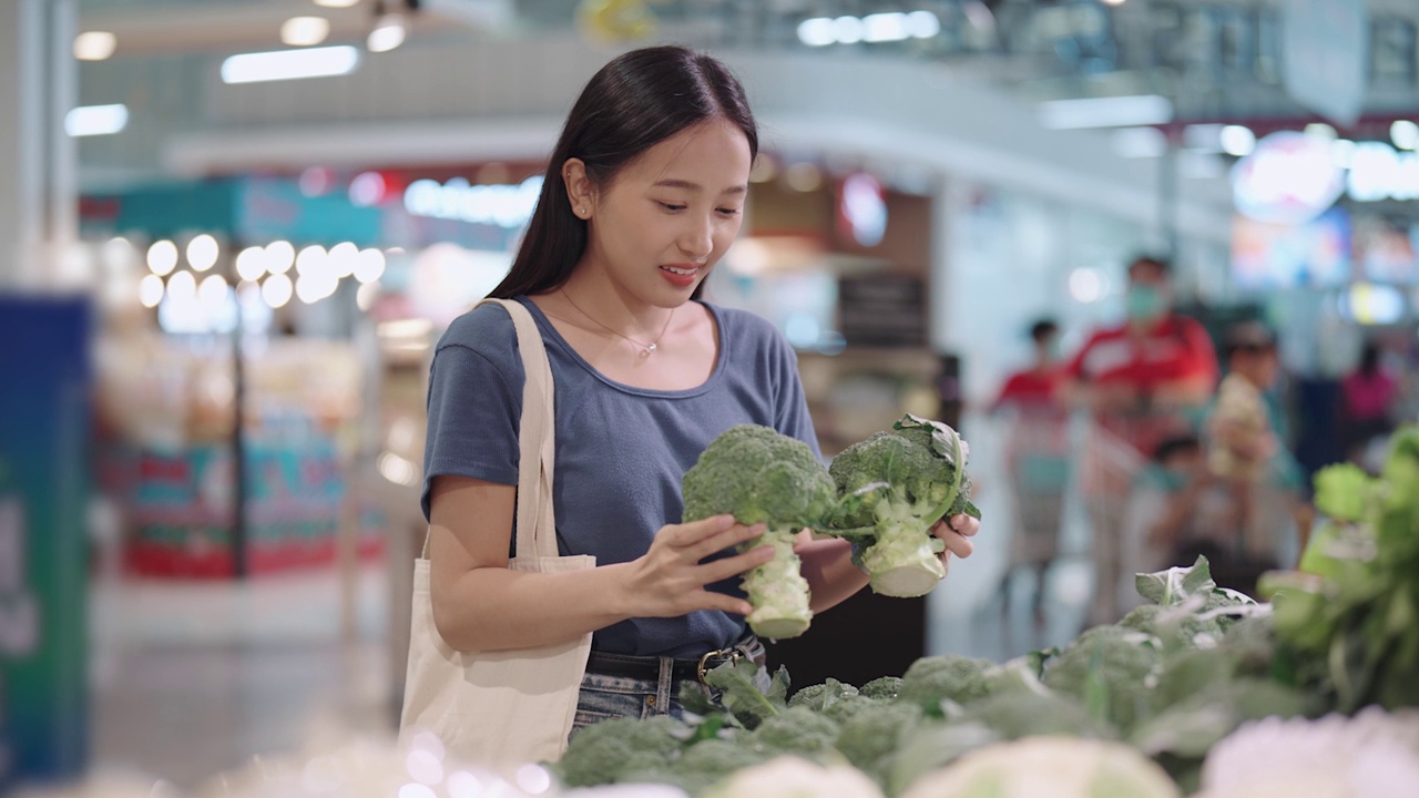 一位亚洲妇女在杂货店挑选蔬菜视频素材