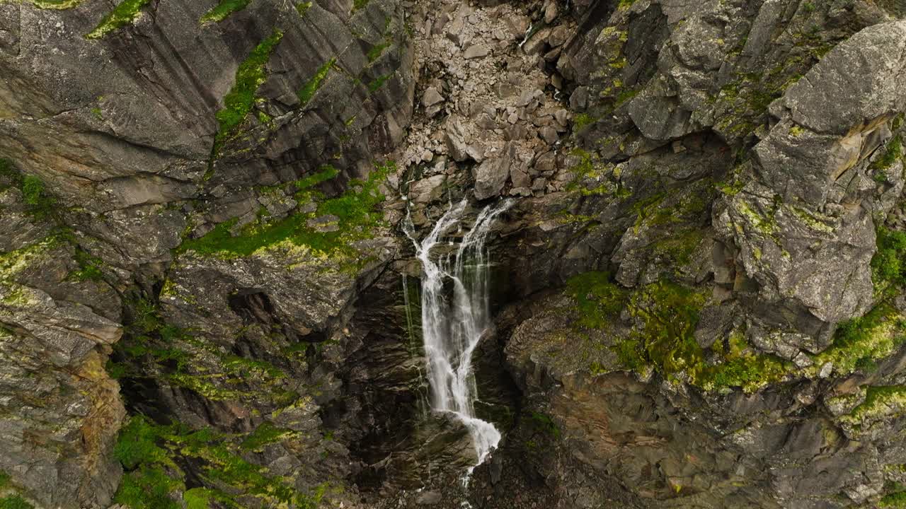 挪威北部赫尔莫尤韦高山峡谷悬崖边的瀑布。空中倾斜镜头视频素材