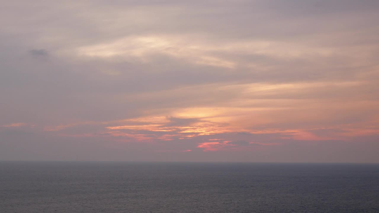 美丽的日落在海岸线热带悬崖与金色的大海，香草的天空和剪影棕榈树对着海洋水面，自然的海洋夏季热带日落背景视频素材