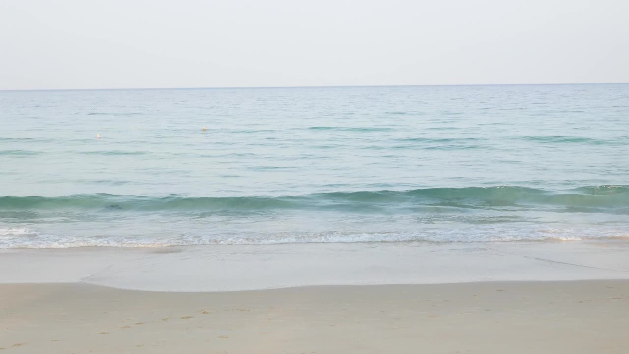 夏天的大海在阳光明媚的日子美丽的热带海滨风景在普吉岛海滩与海浪冲击沙滩，暑假假期背景在4k视频。视频素材