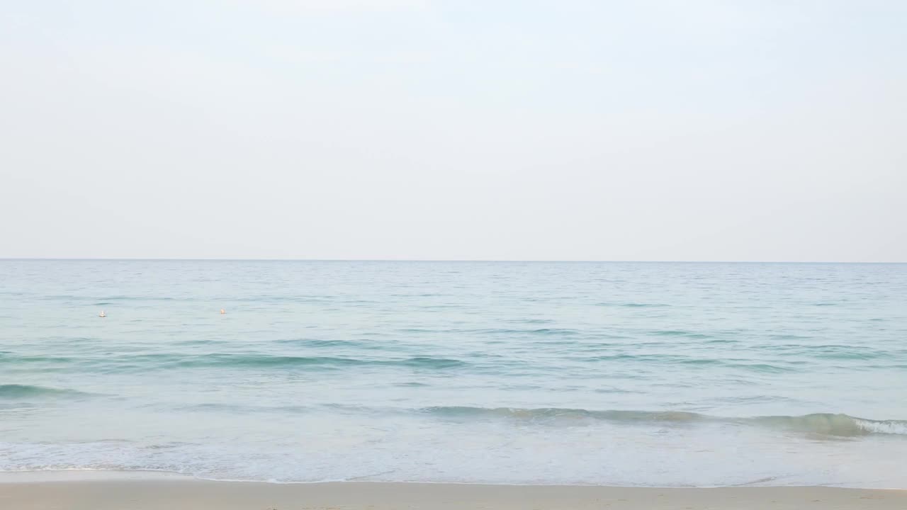 夏天的大海在阳光明媚的日子美丽的热带海滨风景在普吉岛海滩与海浪冲击沙滩，暑假假期背景在4k视频。视频素材