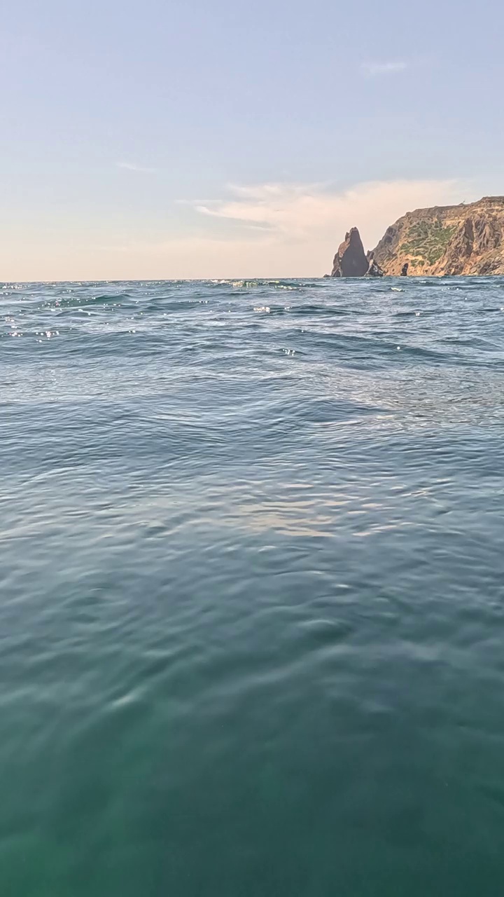 海水表面。从皮艇的低角度看，相机飞过清澈的海水。没有人。假日休闲概念。抽象航海夏季海洋自然。缓慢的运动。关闭了。垂直视频视频素材