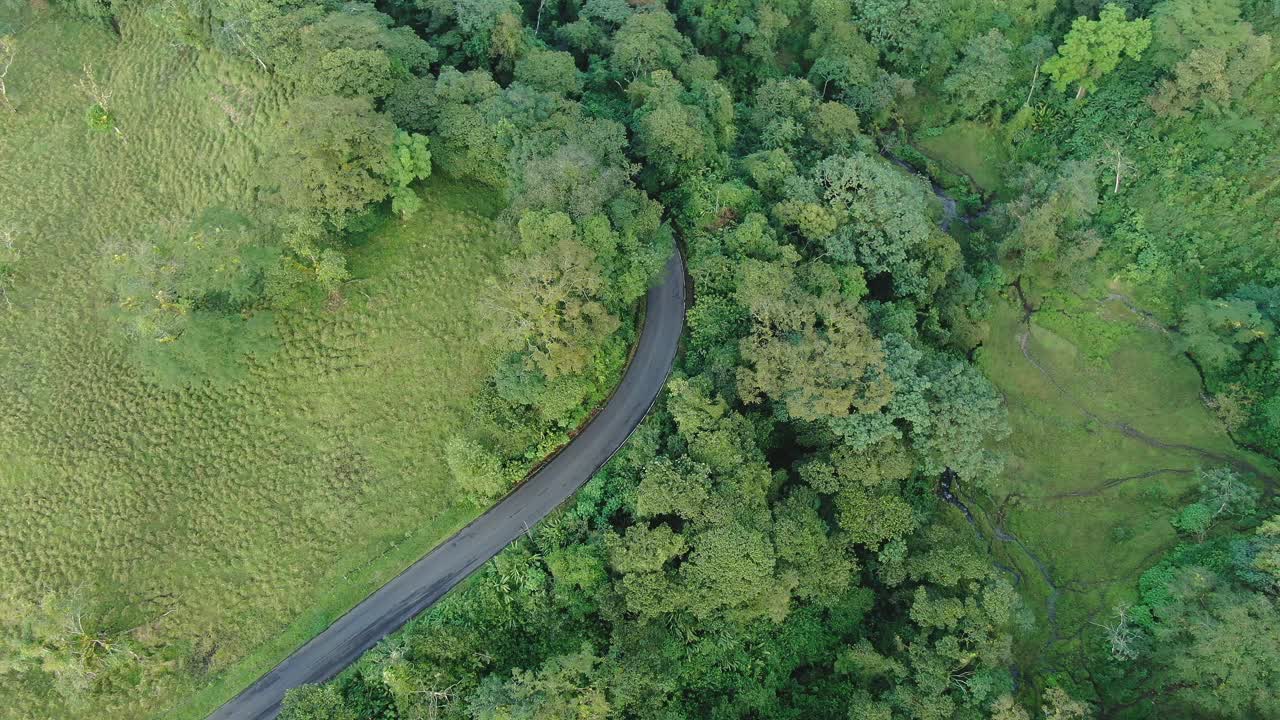 无人机在丛林中俯瞰乡村道路。视频素材