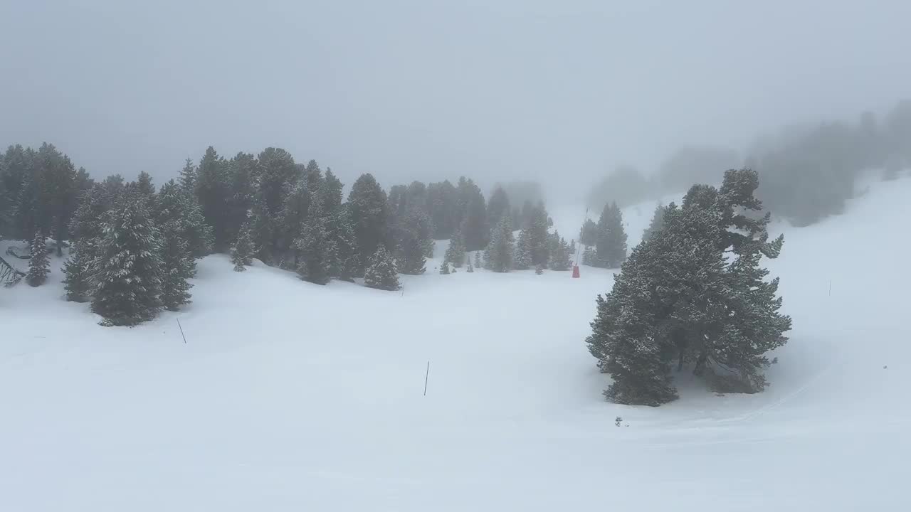 从滑雪缆车俯瞰空无一人的滑雪道。许多冰雪覆盖的树木。库存4K 60fps视频素材