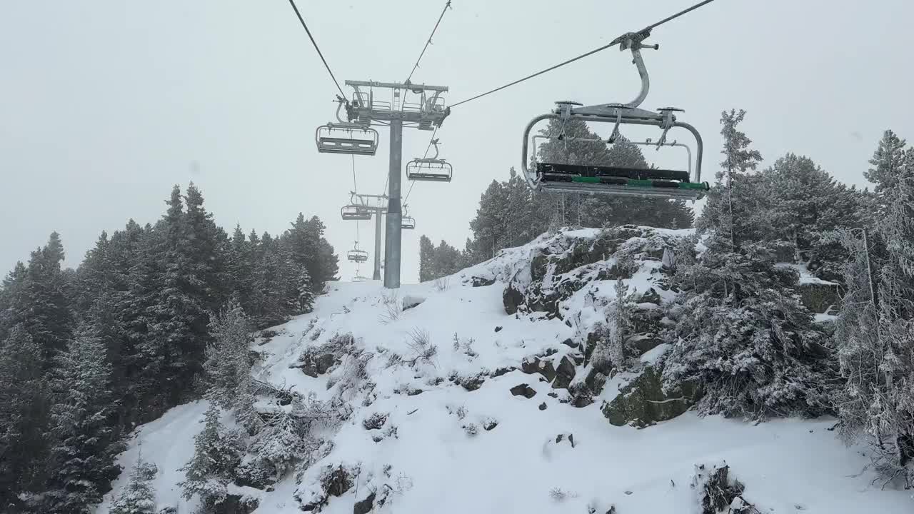 从滑雪缆车俯瞰空无一人的滑雪道。许多冰雪覆盖的树木。库存4K 60fps视频素材