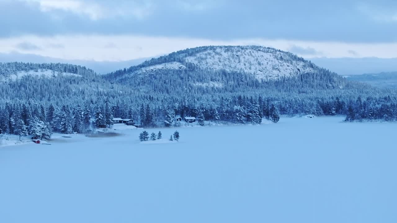 在下雪的冬天，乡村附近的森林山脉。航拍广角视频素材