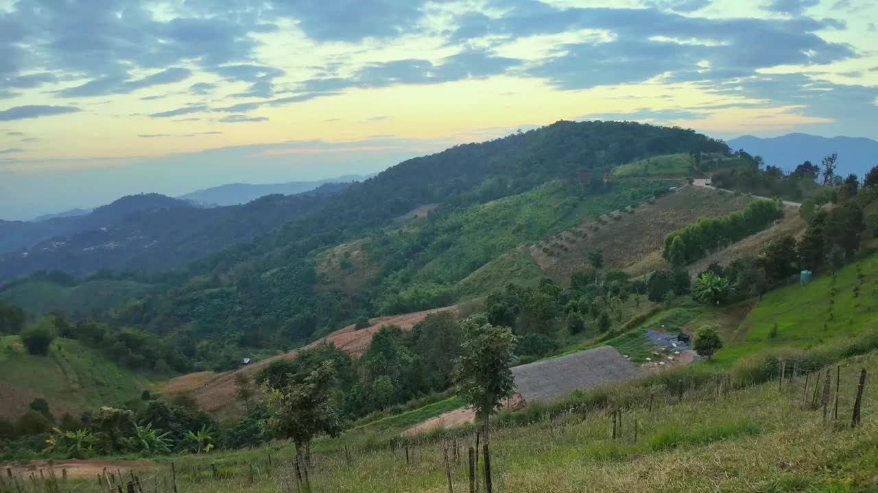 时间流逝的黄金时间，清晨日出，美丽的山景，快速移动的云，天空和汽车穿过道路。位于泰国清莱省的土井山。视频下载