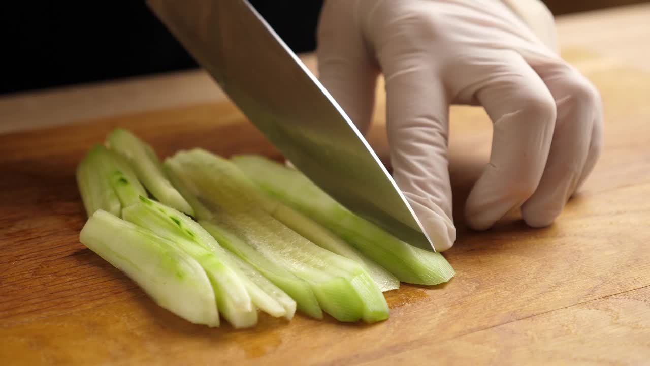 新鲜的黄瓜被切成小块用于烹饪。制作黄瓜菜视频素材