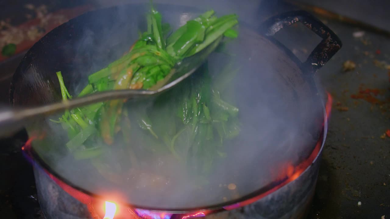 近景厨房用火煎锅炒牵牛花或水菠菜，泰国亚洲美食，泰国街头小吃菜单视频素材