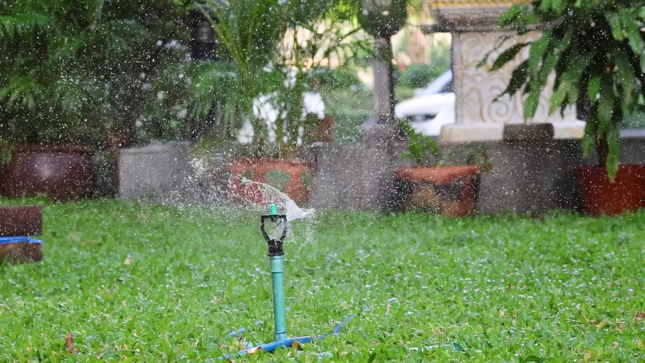 花园洒水器浇灌草坪视频素材