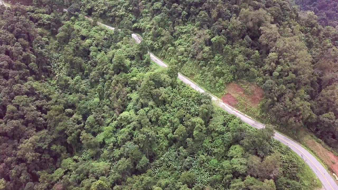 航空物流概念。一条蜿蜒的道路穿过充满活力的热带雨林，创造了一个迷人的自然和交通的融合。视频素材