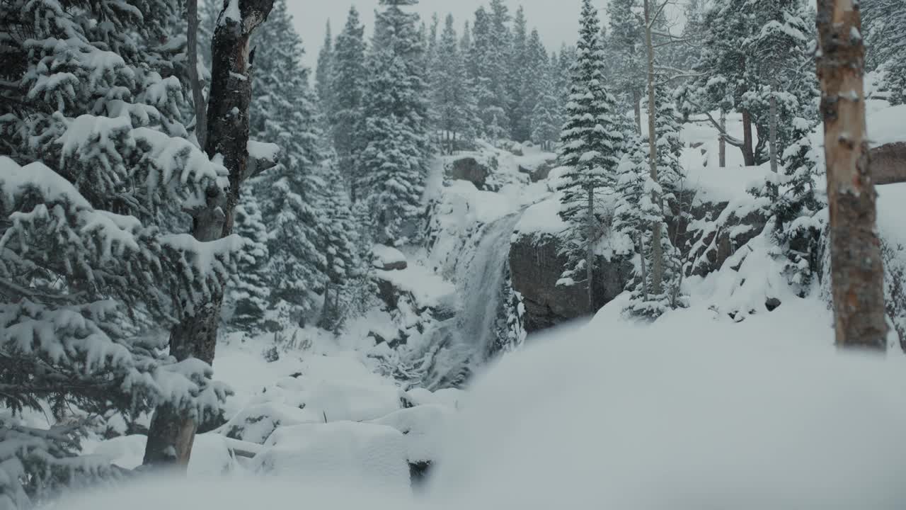 美丽、风景优美的瀑布依偎在山上，雪花纷飞视频素材