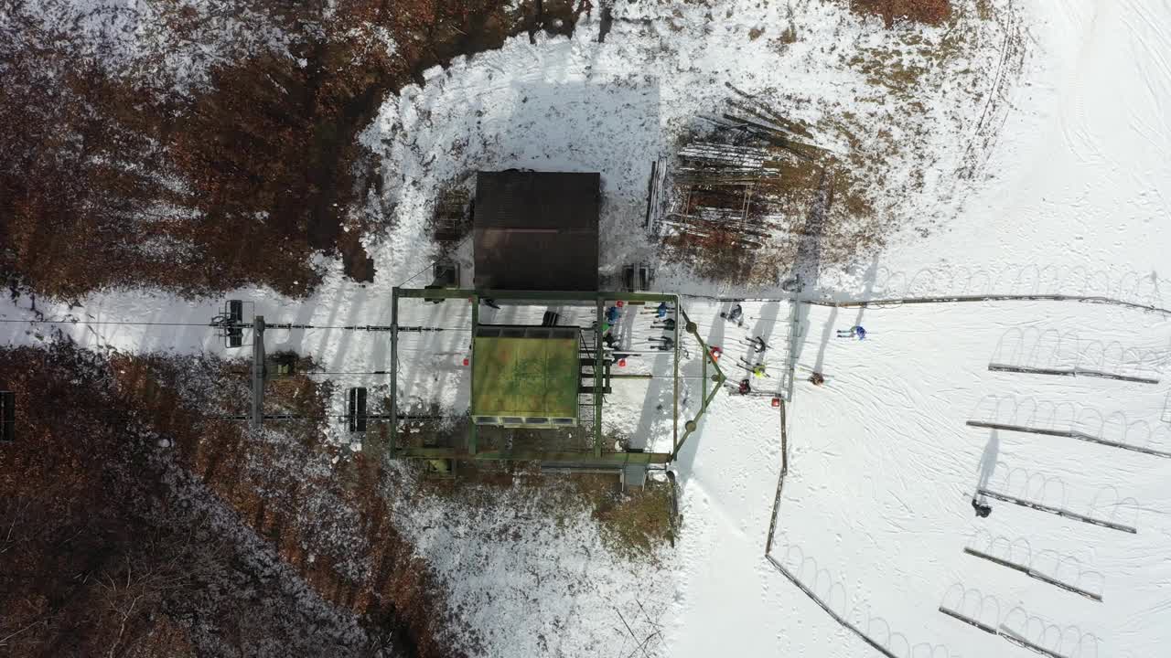 滑雪者在山区度假胜地登上滑雪缆车的鸟瞰图视频下载