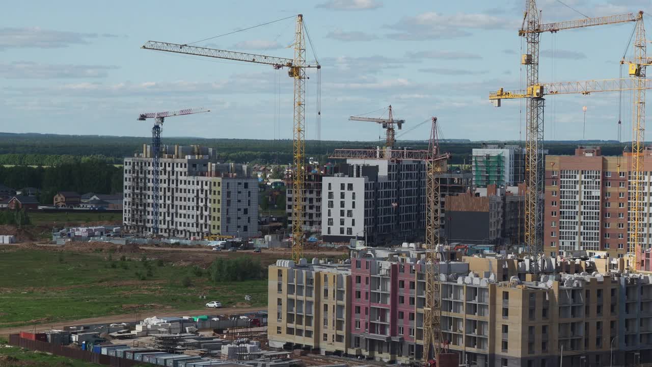 蓝天背景下的新建筑工地。钢框架结构、结构钢梁在施工现场建造大型建筑物。工程机械。现代城市视频素材