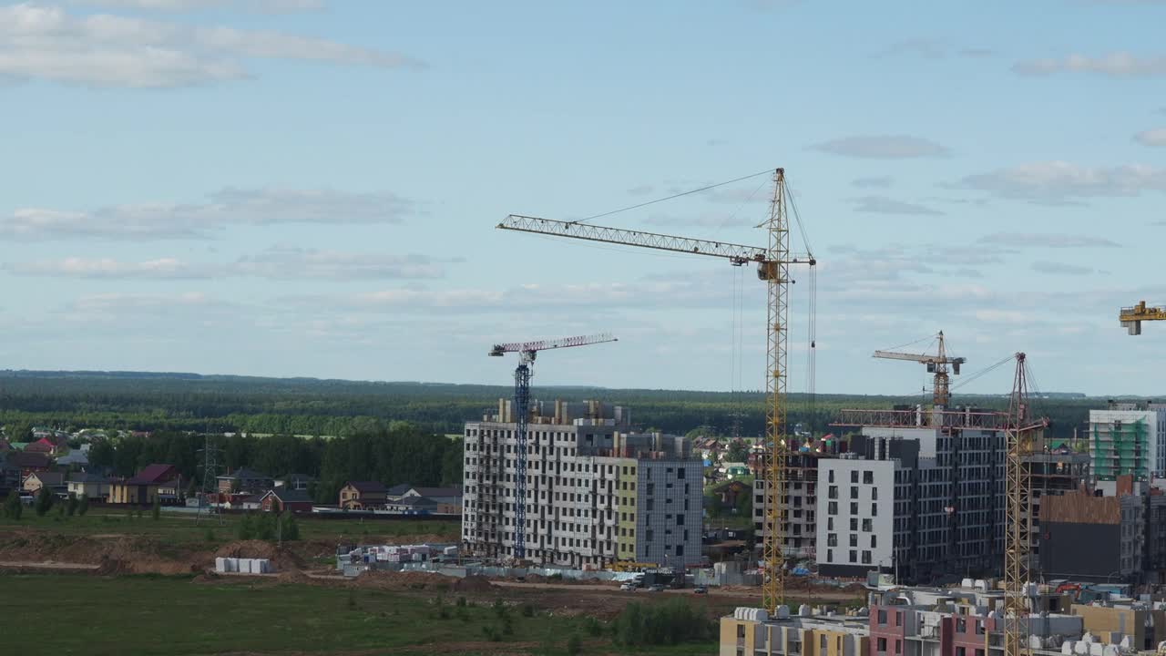 蓝天背景下的新建筑工地。钢框架结构、结构钢梁在施工现场建造大型建筑物。工程机械。现代城市视频素材