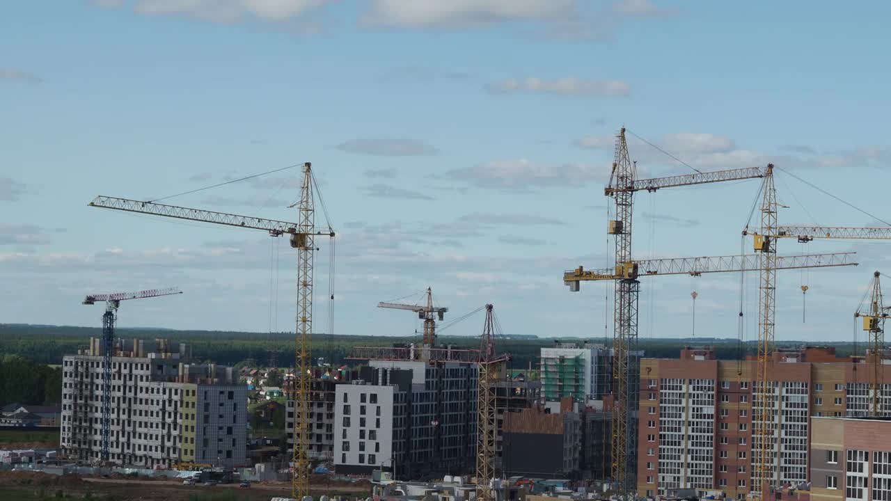 蓝天背景下的新建筑工地。钢框架结构、结构钢梁在施工现场建造大型建筑物。工程机械。现代城市视频素材