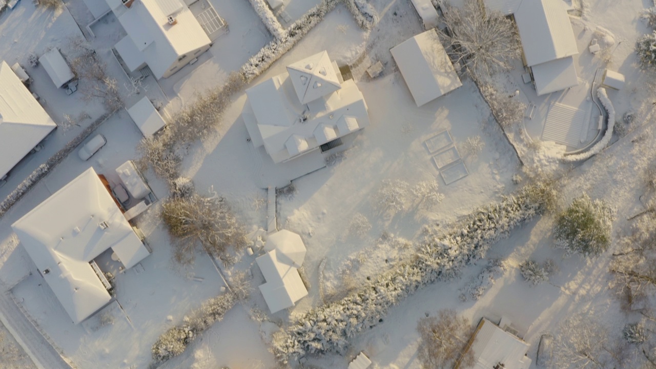 阳光下覆盖着白雪的郊区住宅的俯视图视频下载