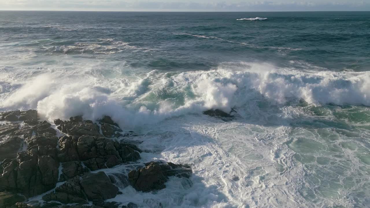 汹涌的海浪翻滚在泡沫表面在蓬特索，科梅科鲁尼亚，西班牙加利西亚视频素材