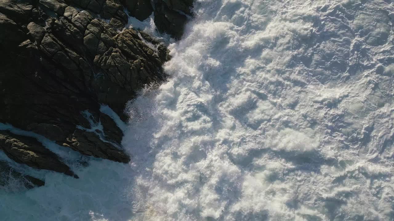 西班牙加利西亚科姆崎岖的海岸上飞溅的泡沫海浪的航拍视频素材