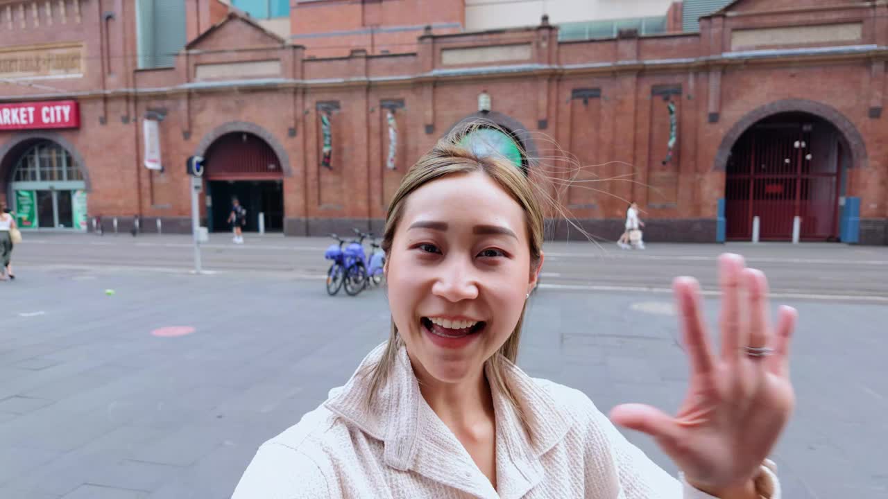 年轻的日本女子拿着相机说话，就像网红在城市旅行视频一样视频素材