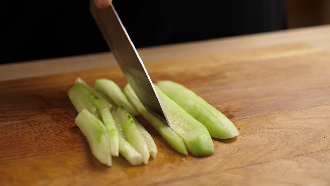 新鲜的黄瓜被切成小块用于烹饪。做黄瓜菜。缓慢的运动。视频素材