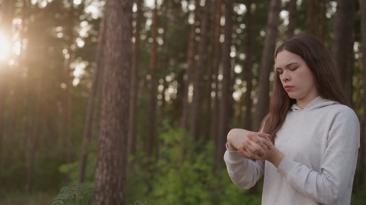 年轻女子在树旁热身手腕视频素材