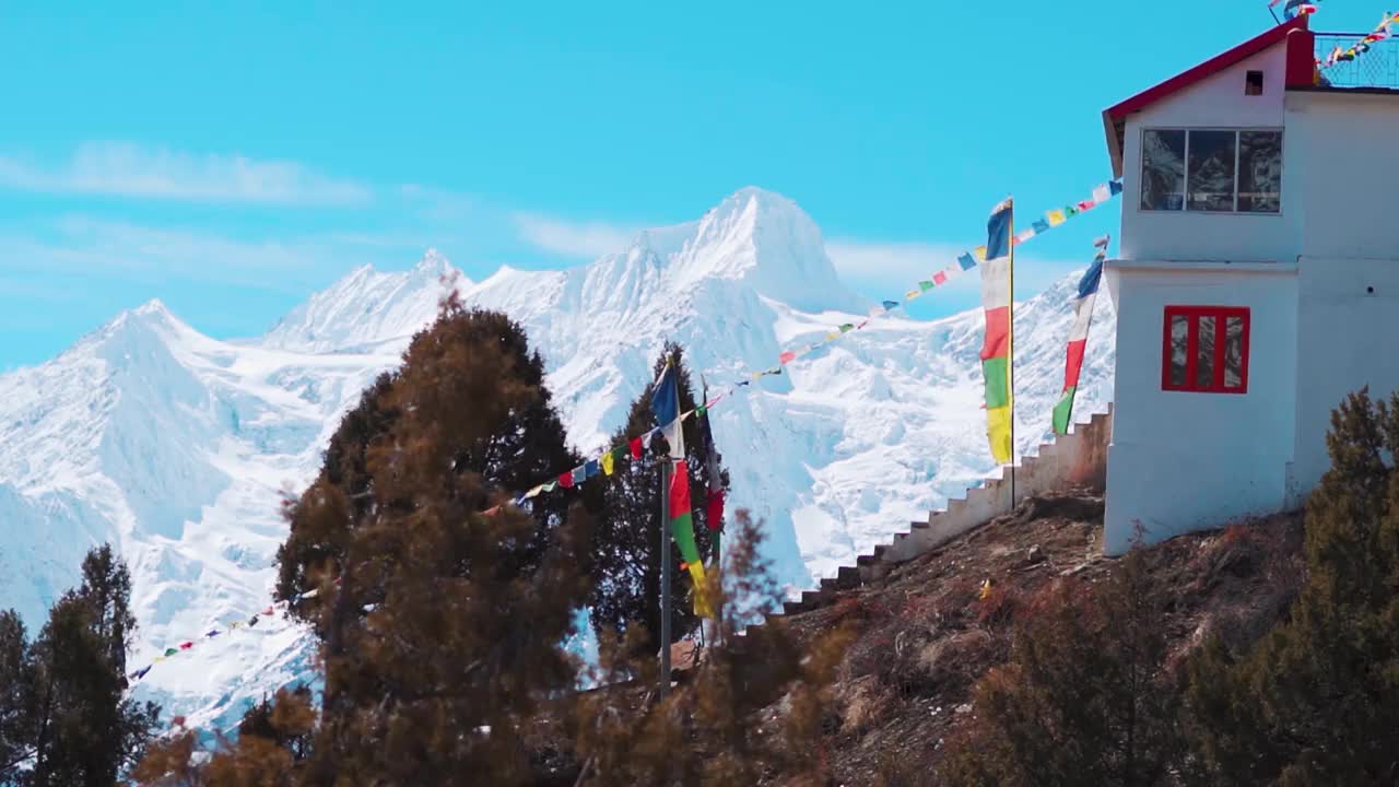 在喜马偕尔邦拉胡尔山谷的沙舒尔寺，冬天，在喜马拉雅雪峰前，经幡在风中飘扬的慢动作镜头。视频素材