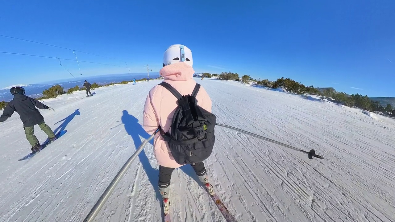 年轻的业余女子滑雪下山。视频素材