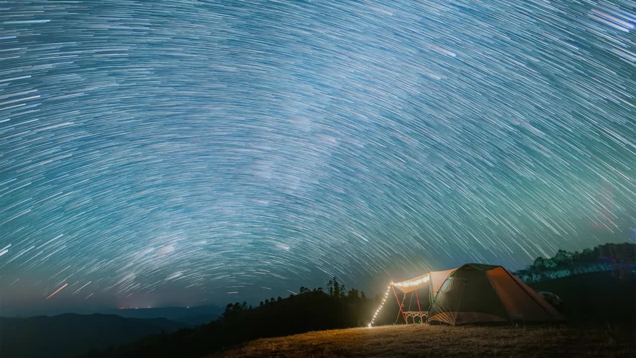 夜景与帐篷露营在山上与流星雨，星星，和宁静的自然视频素材