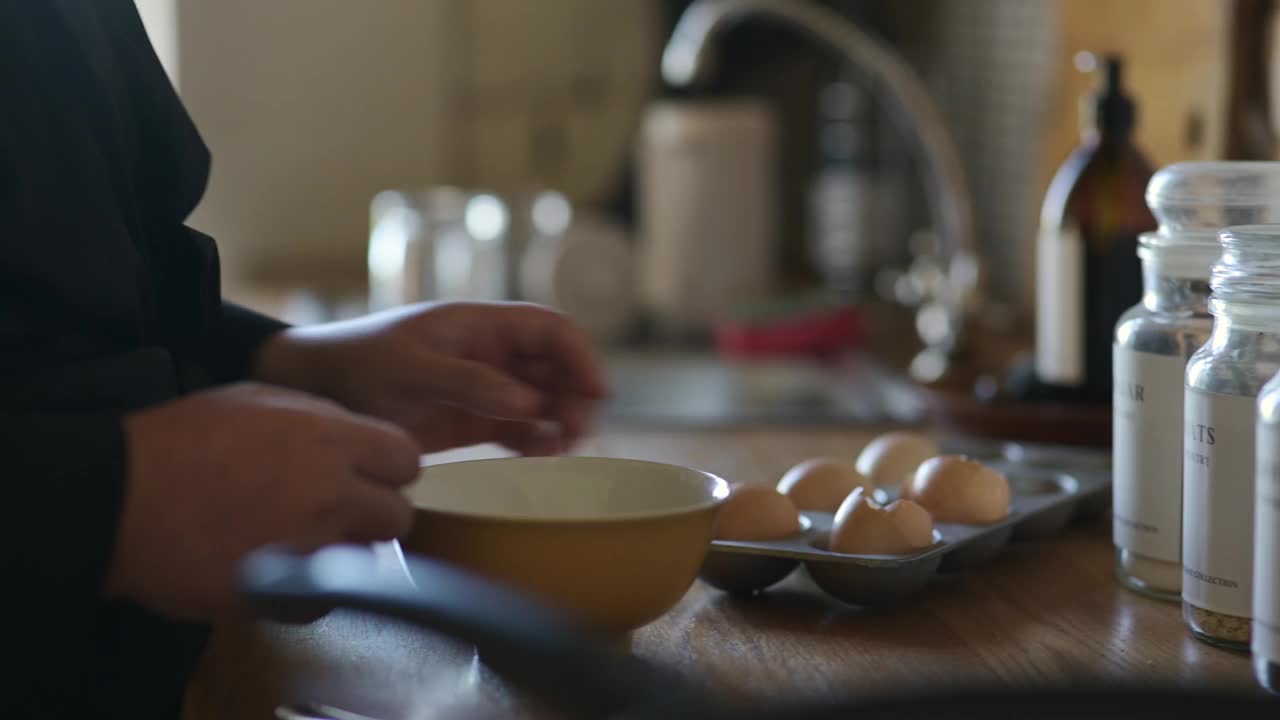 手，鸡蛋和裂缝在碗里煮煎蛋卷或健康早餐，营养或蛋白质。人，手指和贝壳放在厨房柜台上，为饥饿的早晨在家提供纤维，原料或食谱视频素材