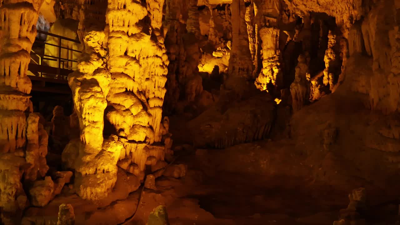 在充满钟乳石的洞穴中进行地下旅行。探索地下旅行，石灰岩奇观。在色彩斑斓的古老洞穴中体验地下之旅视频素材