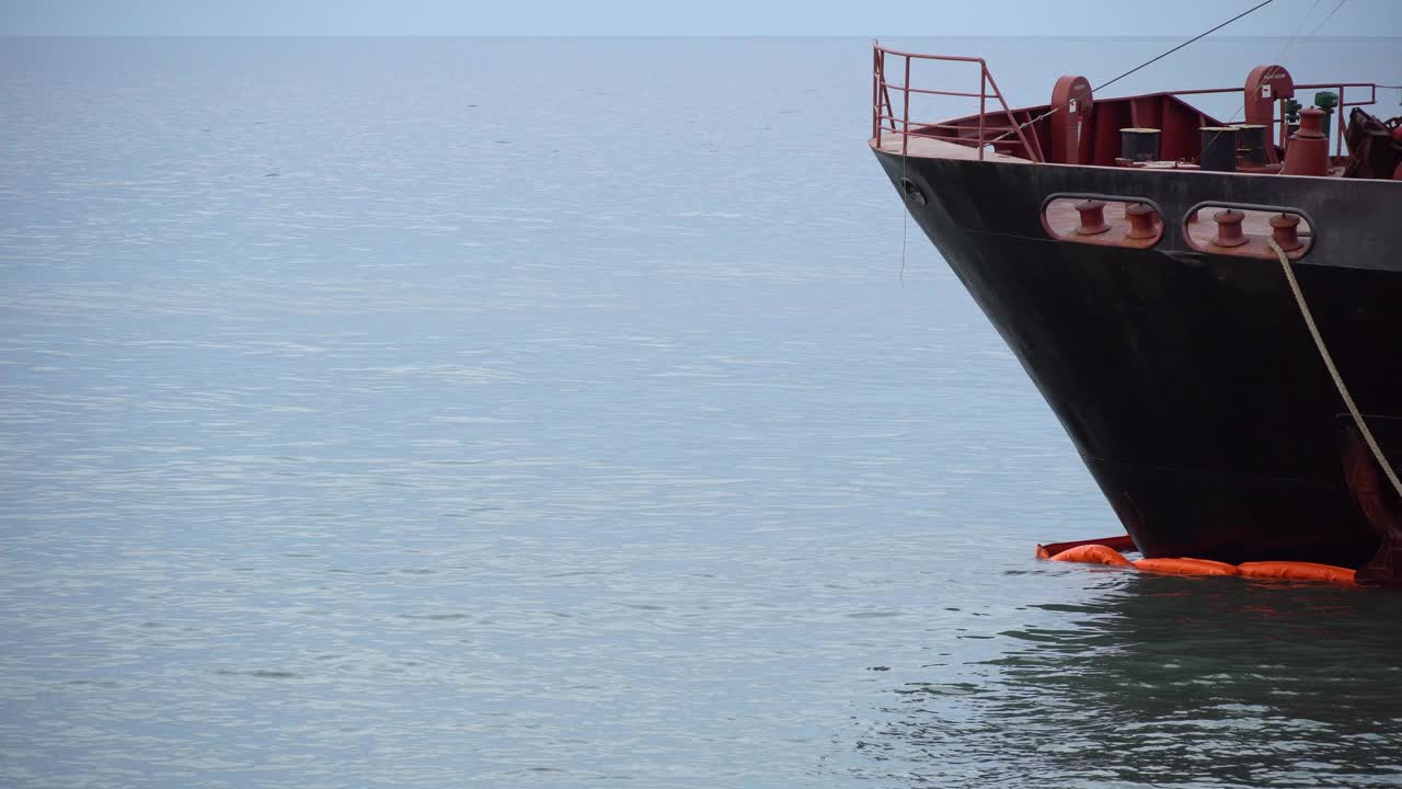 船首停泊在海港，海浪冲刷着运输渡轮、集装箱船或驳船的船尾。海运，国际贸易视频素材