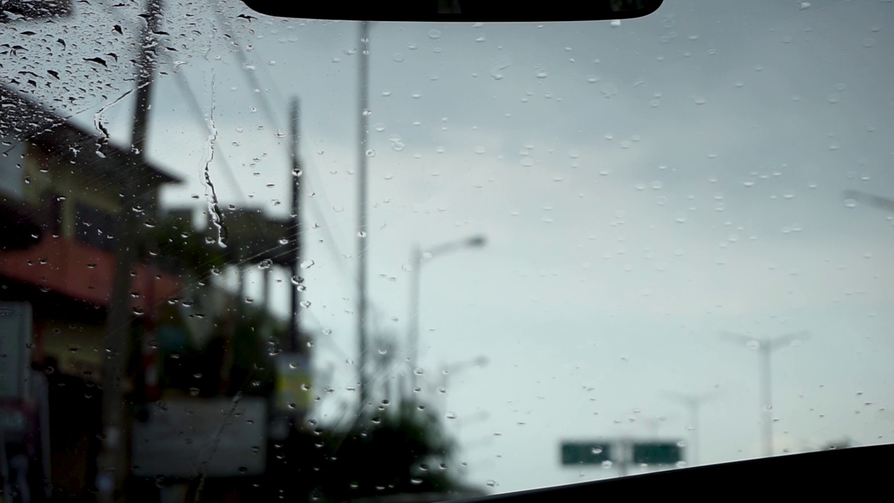 雨刮器在下雨天擦车窗上的雨滴。汽车挡风玻璃上有雨滴视频下载