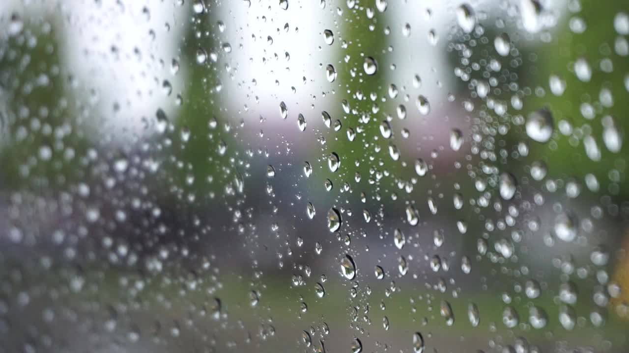 从车内看雨景。雨中从汽车挡风玻璃看到的交通景象。在雨中开车。视频下载