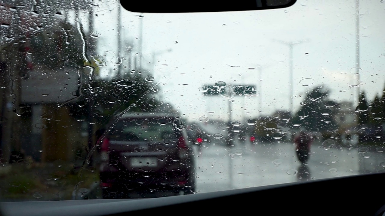 雨刮器在下雨天擦车窗上的雨滴。汽车挡风玻璃上有雨滴视频下载