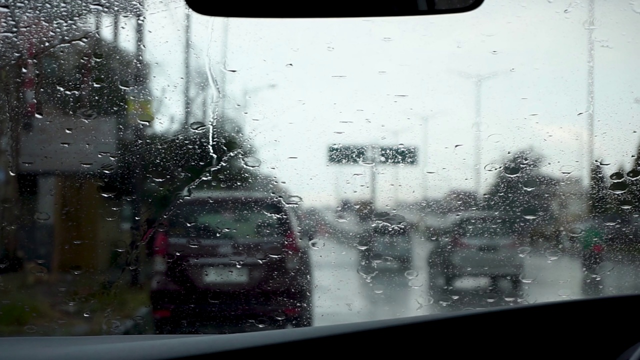 雨刮器在下雨天擦车窗上的雨滴。汽车挡风玻璃上有雨滴视频素材