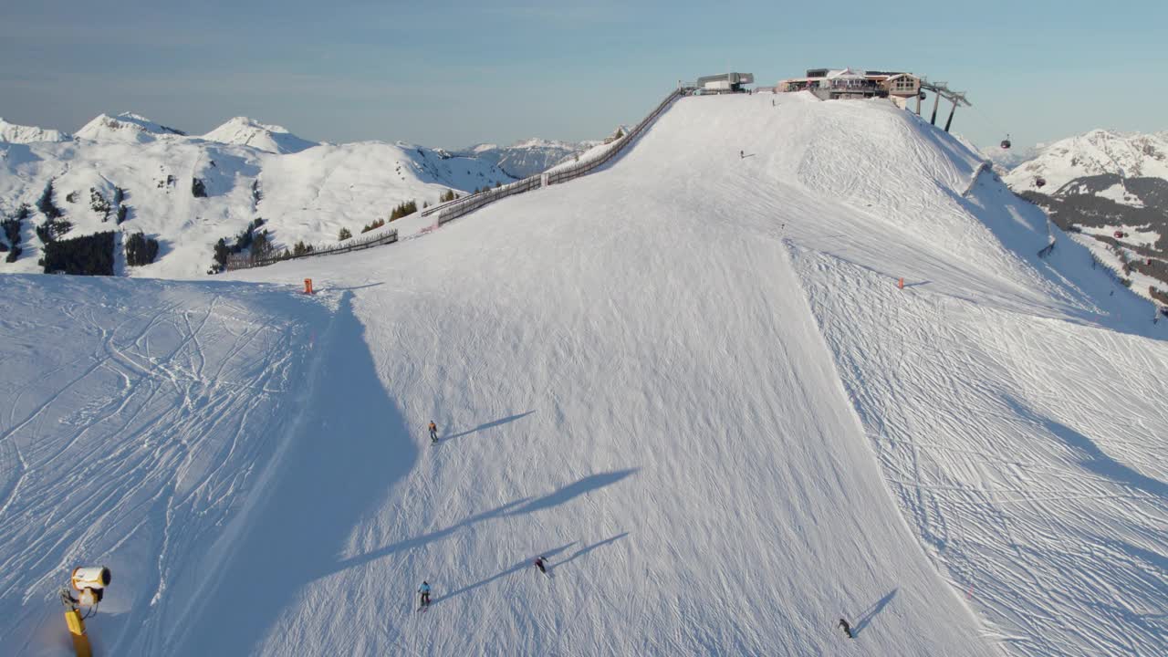 滑雪者在奥地利萨尔巴赫-辛特格勒姆的滑雪胜地滑下滑雪坡——无人机拍摄视频素材