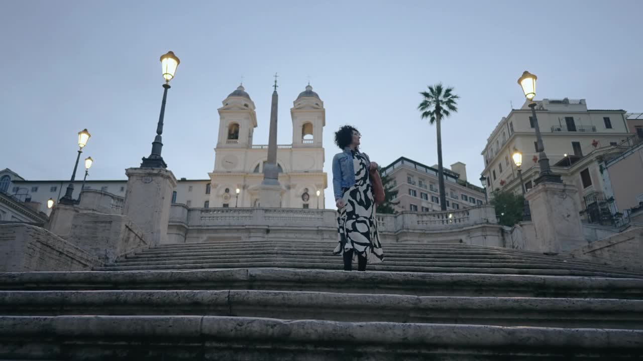 电影拍摄的时尚时尚女模特观光西班牙台阶在罗马，意大利背景风景如画的圣三一教堂。慢moiton视频素材