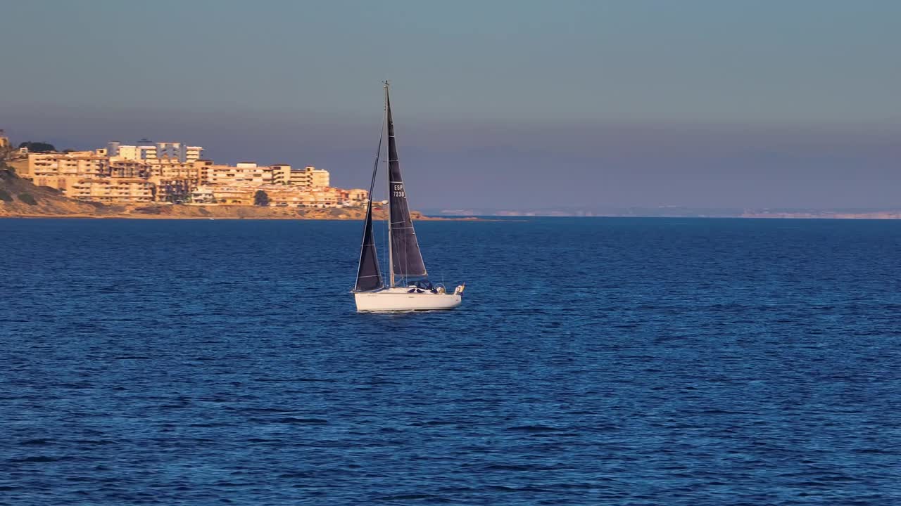 美丽的帆船航行在热带异国情调的海湾与深蓝色的大海。在夕阳的余晖中建立游艇的航拍。无人机拍摄的海上帆船的剪影视频素材