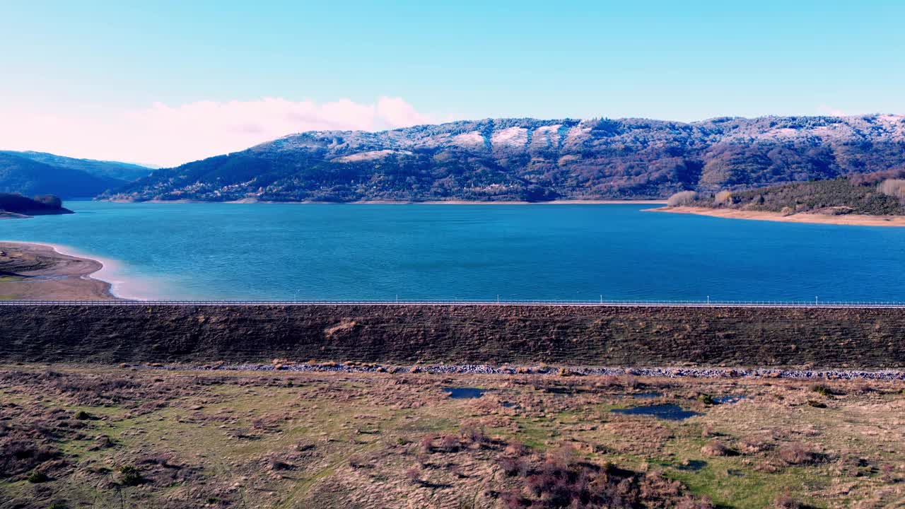 宁静的湖泊与白雪覆盖的山脉为背景，马其顿的马夫罗沃国家公园，从高处俯瞰视频下载