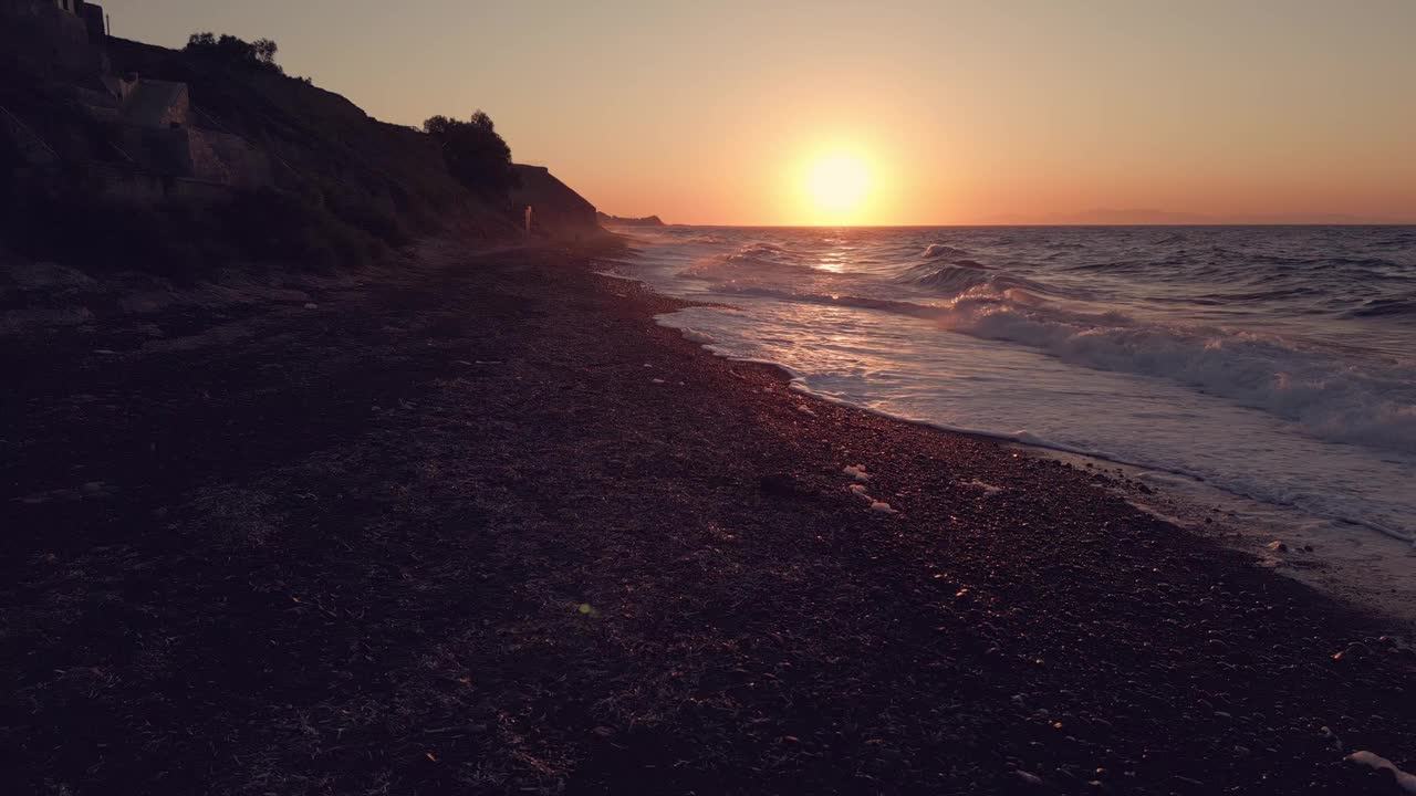 日落在圣托里尼海滩与温柔的海浪视频素材