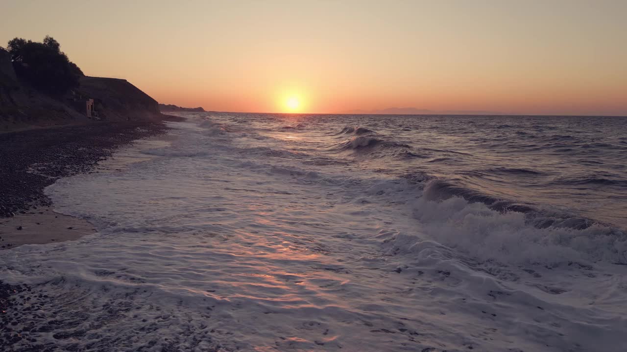 圣托里尼海滩日落与海浪和黄昏的天空视频素材