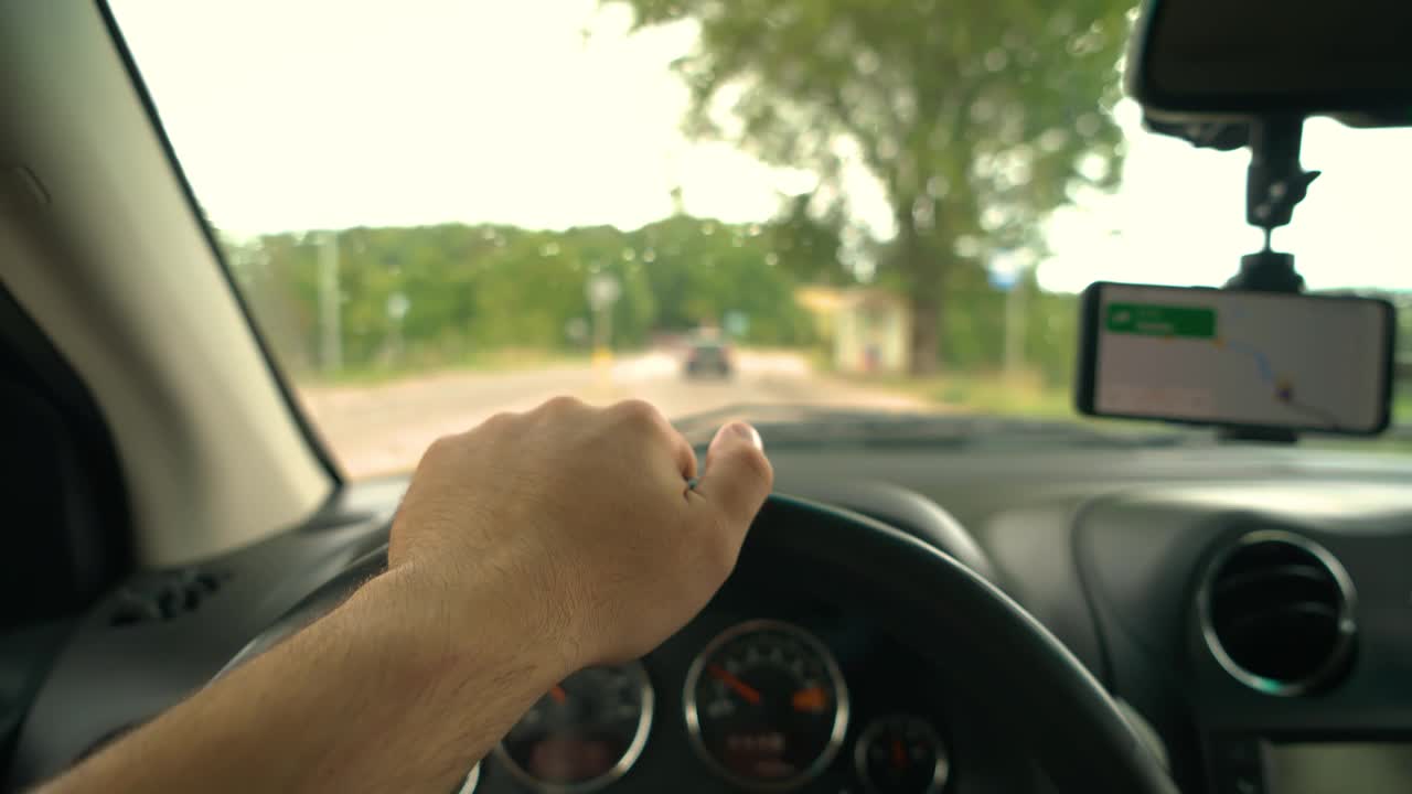 在交通高峰期，一名男子双手放在方向盘上快速驾驶汽车，以控制车辆驶向目的地视频素材