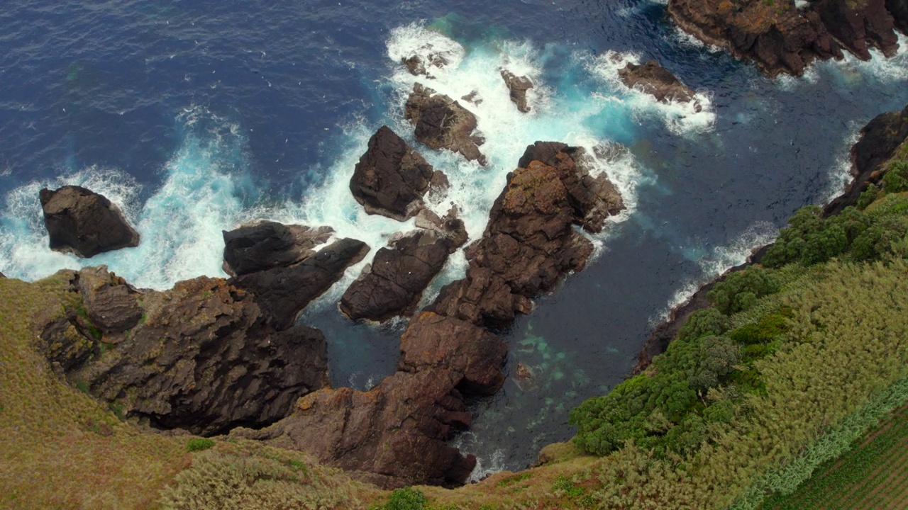 鸟瞰大西洋海水在岩石海岸线上破碎的海浪视频素材