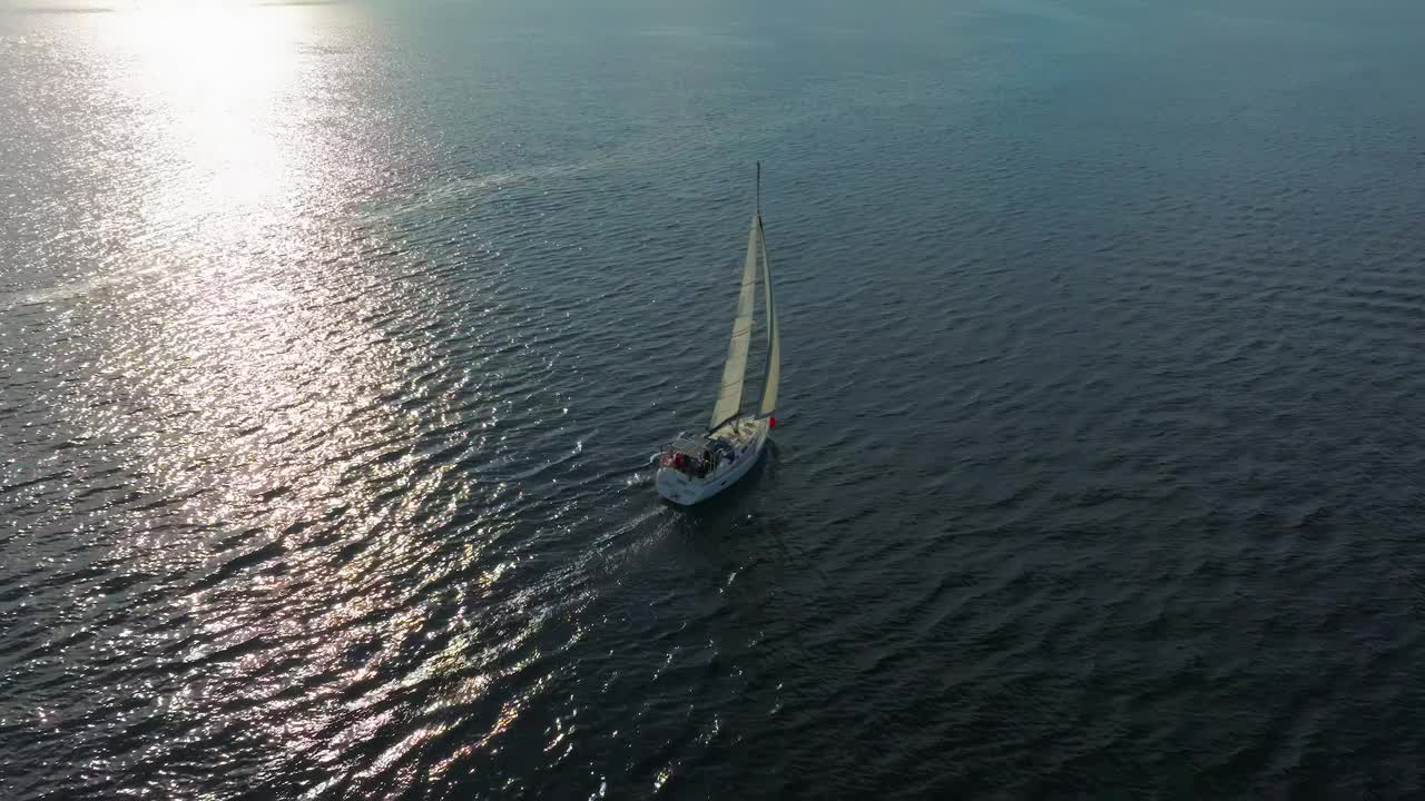 美丽的帆船航行在热带异国情调的海湾与深蓝色的大海。在夕阳的余晖中建立游艇的航拍。无人机拍摄的海上帆船的剪影视频素材