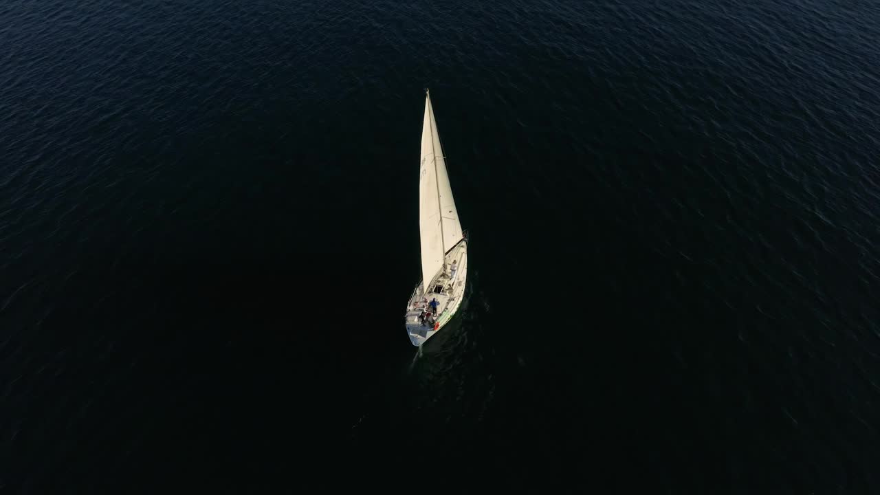 美丽的帆船航行在热带异国情调的海湾与深蓝色的大海。在夕阳的余晖中建立游艇的航拍。无人机拍摄的海上帆船的剪影视频素材